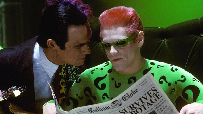 Batman Forever Two-Face speaks with Riddler as he reads a newspaper