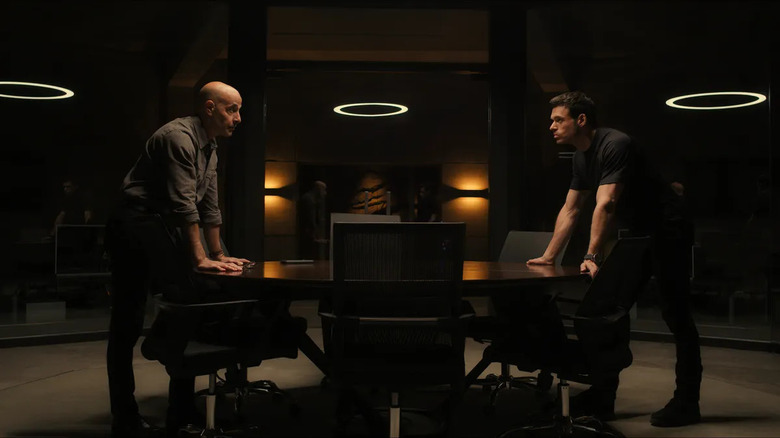 Stanley Tucci as Bernard Orlick and Richard Madden as Mason Kane standing at table in Citadel