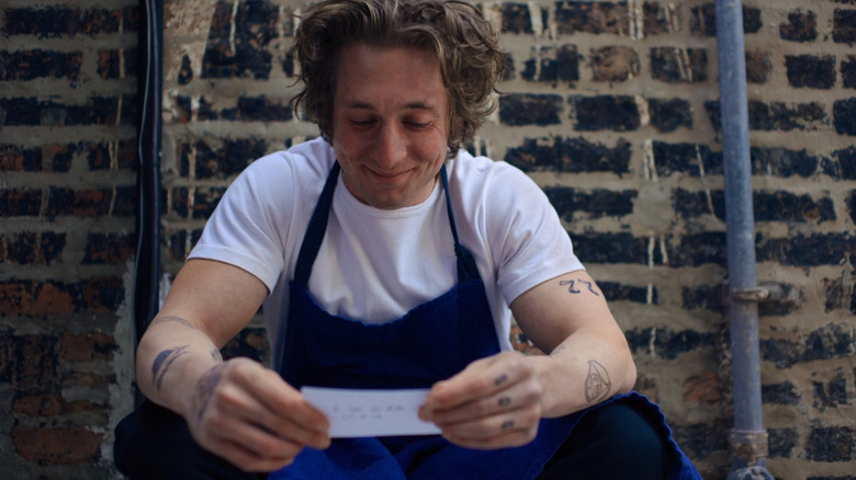 Jeremy Allen White holding a piece of paper in The Bear