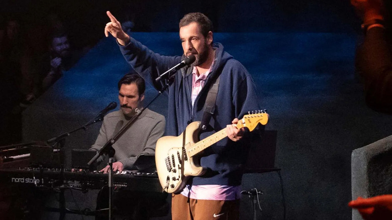 Adam Sandler playing guitar and pointing up in Love You