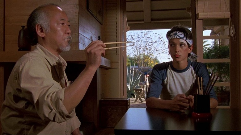 Ralph Macchio watches Pat Morita catch a fly using chopsticks in The Karate Kid