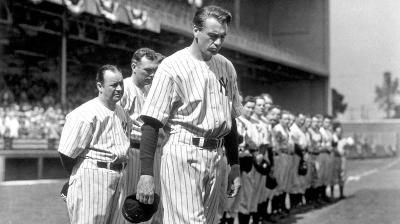 Gary Cooper as Lou Gehrig stands in a line with Yankees preparing to give farewell speech