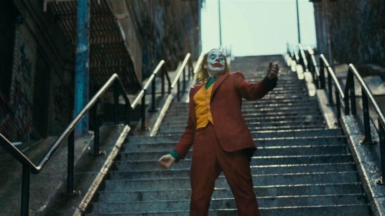 Joaquin Phoenix as Joker dancing down the stairs